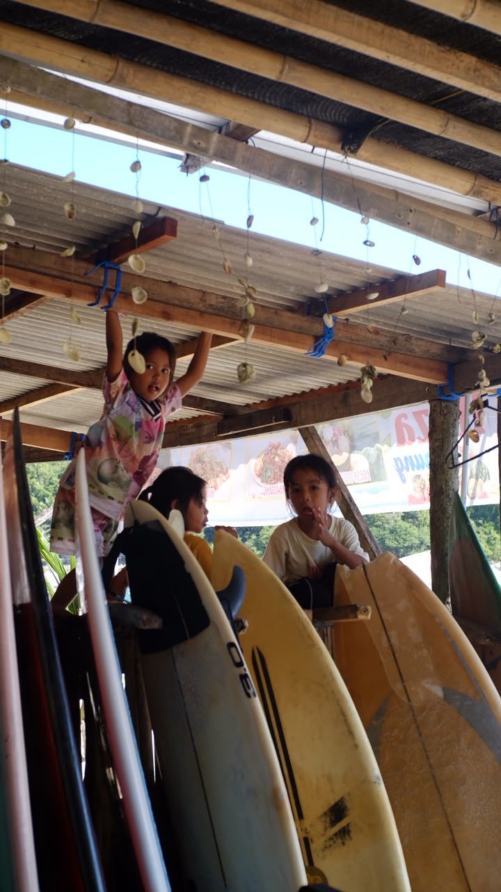 Kids playing near the surfboard racks at the beach shack
