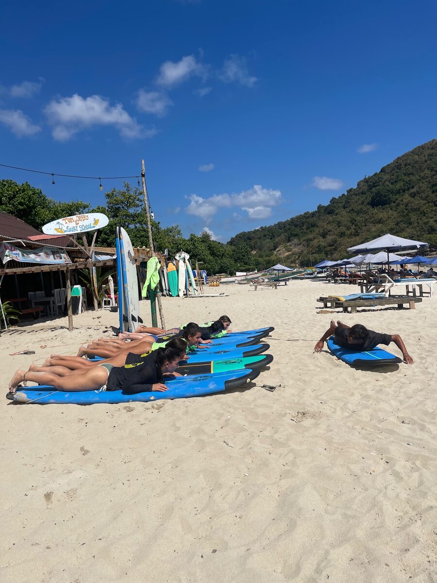 Group stretching on surfboards on the beach