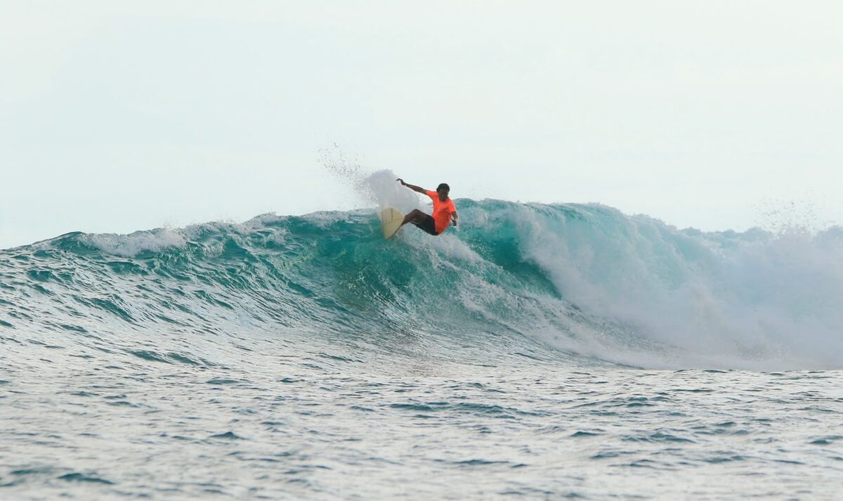 Surfer carving down the face of a wave in Lombok
