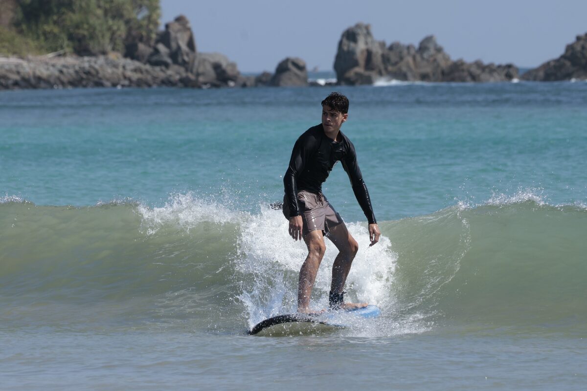 Student surfing a small wave in Lombok